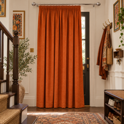 Burnt Orange Thermal Door Curtain in a Hallway with White Walls and Dark Wooden Stairs