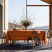 Burnt Orange Rectangular Linen Tablecloth in a Mid-Century Modern Dining Room with Floor-to-Ceiling Windows