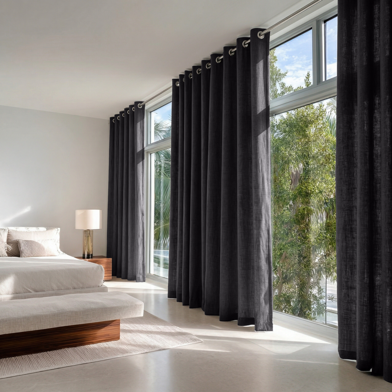 Charcoal Grey Linen Eyelet Curtains in a Bright Minimal Bedroom with Warm White Walls and Light Flooring