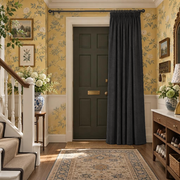Charcoal Grey Thermal Door Curtain in a Hallway with Yellow Floral Wallpaper 