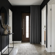 Thermal Door Curtains in a Hallway with Dark Grey Walls and a Wooden Front Door