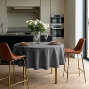 Dim Grey Linen Round Tablecloth in a Modern Kitchen Dining Space with Cream Cabinetry and Tan Leather Chairs