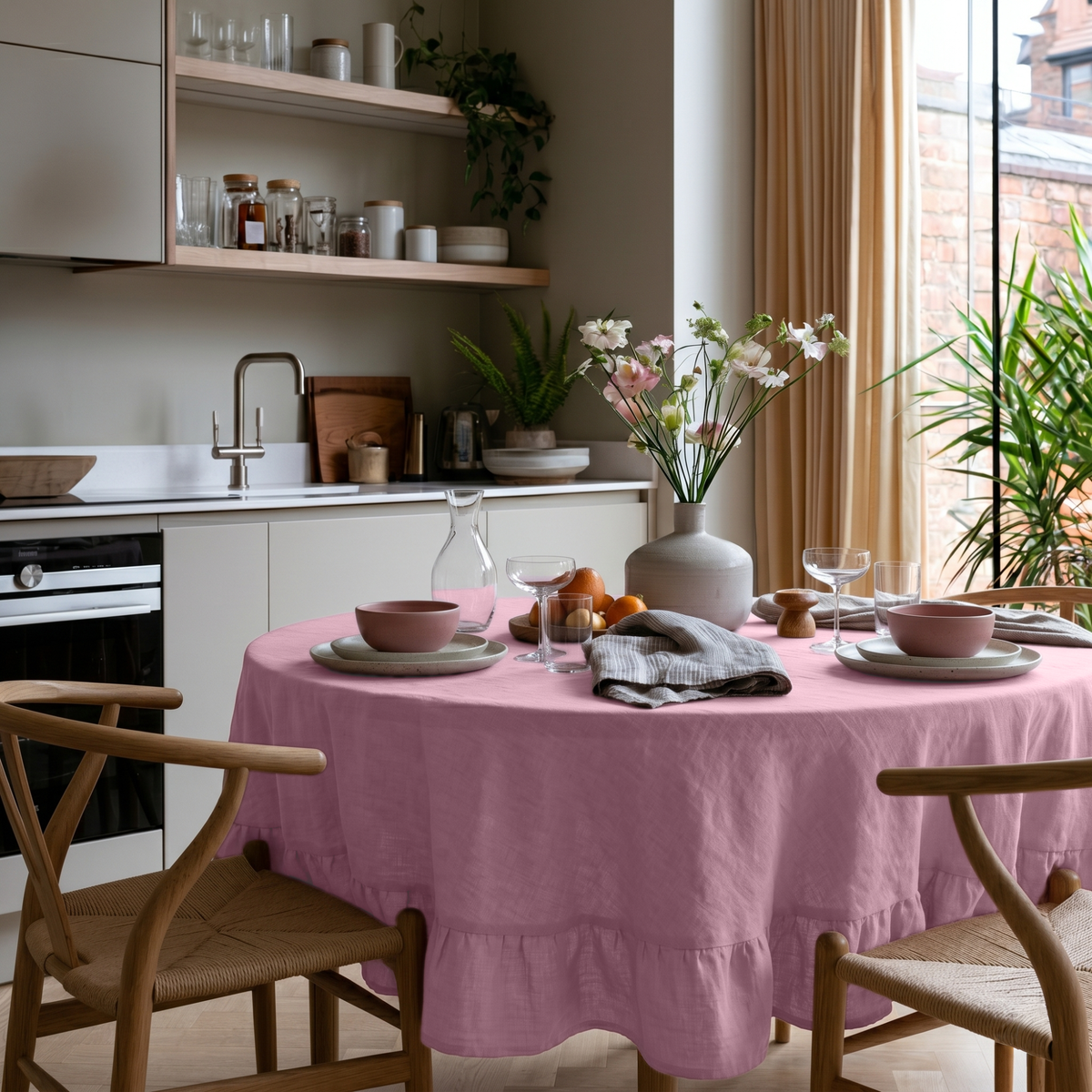Dusty Rose Linen Round Ruffle Tablecloth in a Bright Kitchen Dining Space with Soft Beige Walls and Light Wood Chairs