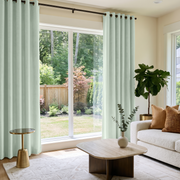 Mint Green Velvet Eyelet Curtains in a Modern Living Room with a White Bouclé Sofa and Brass Side Table