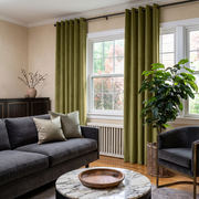 Moss Green Velvet Eyelet Curtains in a Contemporary Living Room with Beige Walls and a Charcoal Sofa