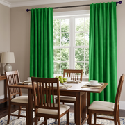 Bright green curtain panels hanging on a dark curtain rod in a dining room setting with a wooden table and chairs.