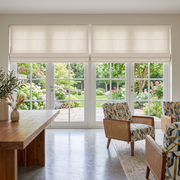 Cream Roman Blinds in a Dining Room with Off-White Walls and a Wooden Table