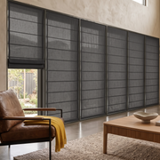 Dim Grey Roman Blinds in a Spacious Living Room with Warm Beige Walls and a Leather Armchair