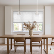 Off-White Roman Blinds in a Dining Room with White Walls and a Wooden Dining Table