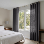 Dim Grey Linen Eyelet Curtains in a Minimal Bedroom With Soft Beige Walls and Warm Wood Furniture