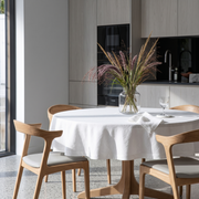 White Linen Round Tablecloth in a Minimal Kitchen Dining Space with Light Oak Cabinetry
