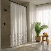 Off-White Linen Ruffle Shower Curtain in a Bright Bathroom with Soft Marble Walls