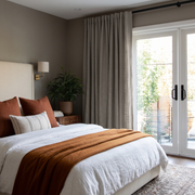 Natural Heavy Weight Linen Back Tab Curtains for Sliding Door in a Modern Bedroom with Taupe Walls and Rust Bedding