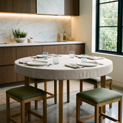 Natural Linen Fitted Round Tablecloth in a Modern Kitchen Dining Space with Marble Backsplash and Light Wood