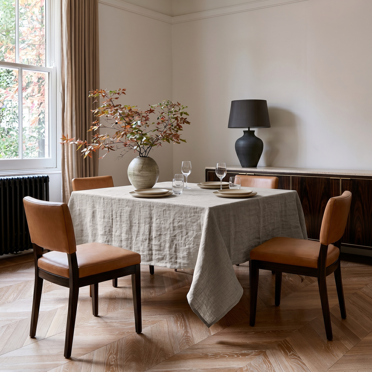 Natural Square Linen Tablecloth in a Transitional Dining Room with Tan Leather Chairs and Dark Wood Sideboard