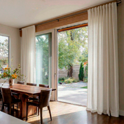 Off-White Heavy Weight Linen Back Tab Curtains for Bifold Doors in a Dining Room with Cream Walls