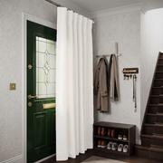 Off-White Heavy Weight Thermal Door Curtain in a Hallway with Light Gray Patterned Wallpaper and a Green Front Door