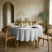 Off-White Velvet Round Ruffle Tablecloth in a Minimal Dining Room with Beige Plaster Walls and Light Wood
