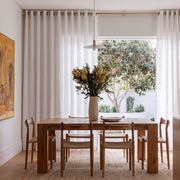 Off-White Linen Eyelets Curtains In A Contemporary Dining Room With White Walls And A Light Oak Dining Table Facing An Outdoor Patio View.