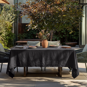Charcoal Grey Rectangular Linen Tablecloth in a Contemporary Outdoor Dining Area with Woven Chairs