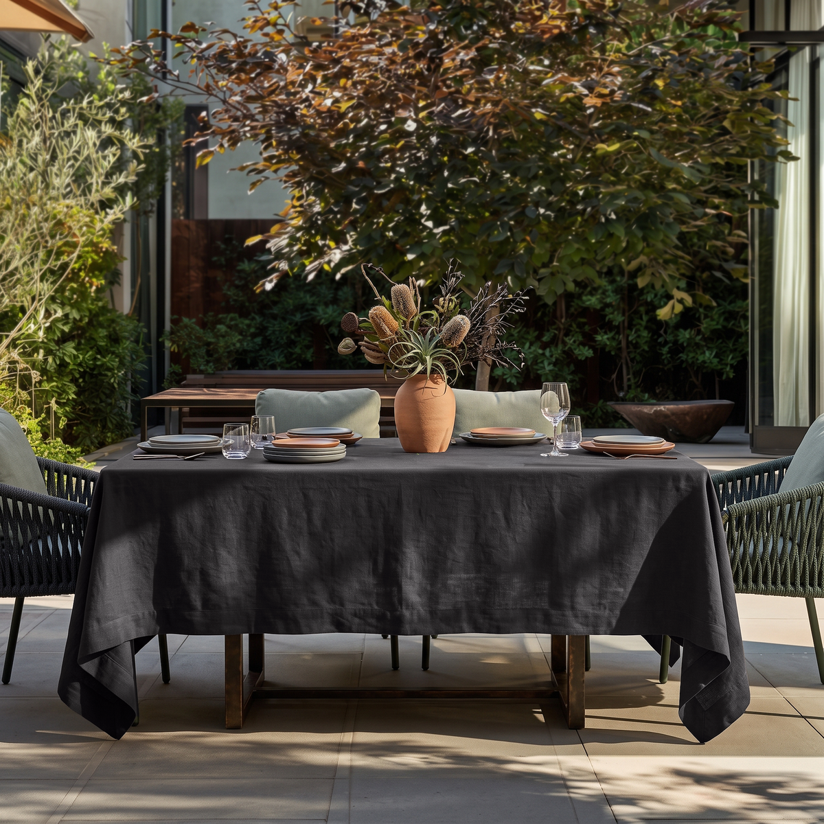 Charcoal Grey Rectangular Linen Tablecloth in a Contemporary Outdoor Dining Area with Woven Chairs