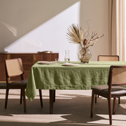 Olive Green Rectangular Linen Tablecloth in a Mid-Century Modern Dining Room with Cane Chairs and Walnut Cabinetry