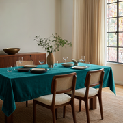 Teal Rectangular Velvet Tablecloth in a Mid-Century Modern Dining Room with Walnut Cane Chairs and Cream Curtains