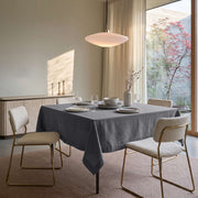 Dim Grey Square Linen Tablecloth in a Contemporary Dining Room with Cream Upholstered Chairs and Floor-to-Ceiling Windows