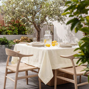 Cream Square Linen Tablecloth on a Contemporary Garden Terrace with Light Wood Chairs
