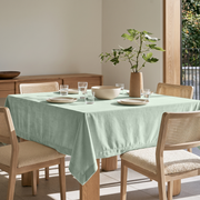 Mint Green Square Velvet Tablecloth in a Modern Dining Room with Cane Chairs and Light Wood Furniture