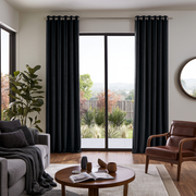 Steel Black Velvet Eyelets Extra Long Curtains in a Modern Living Room with Leather Armchair and Garden View