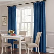 Bright dining room with blue curtains, a white table, and beige chairs.