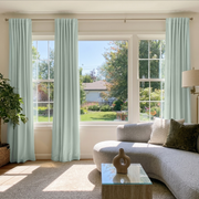 Mint Green Velvet Back Tab Curtains in a Sunlit Living Room with White Walls and Curved Gray Sofa
