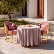 Pink Velvet Round Tablecloth in a Sunlit Patio Dining Setting with Gold-Framed Blush Chairs